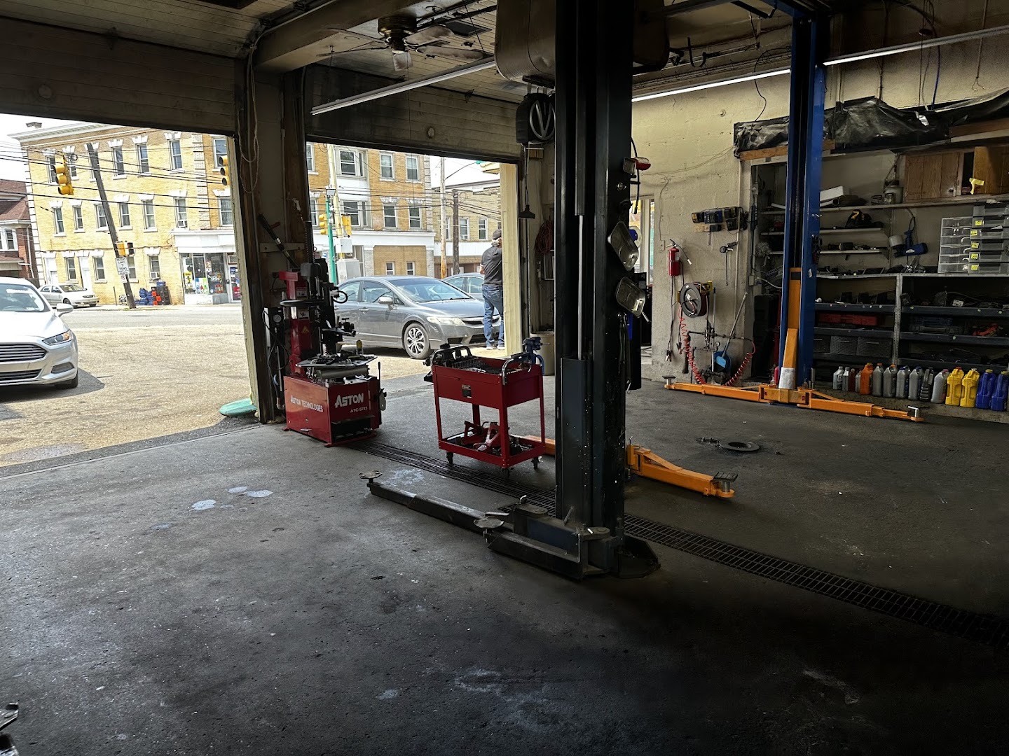 Open service bay door looking onto Brownsville Road with tire mounting equipment in the foreground